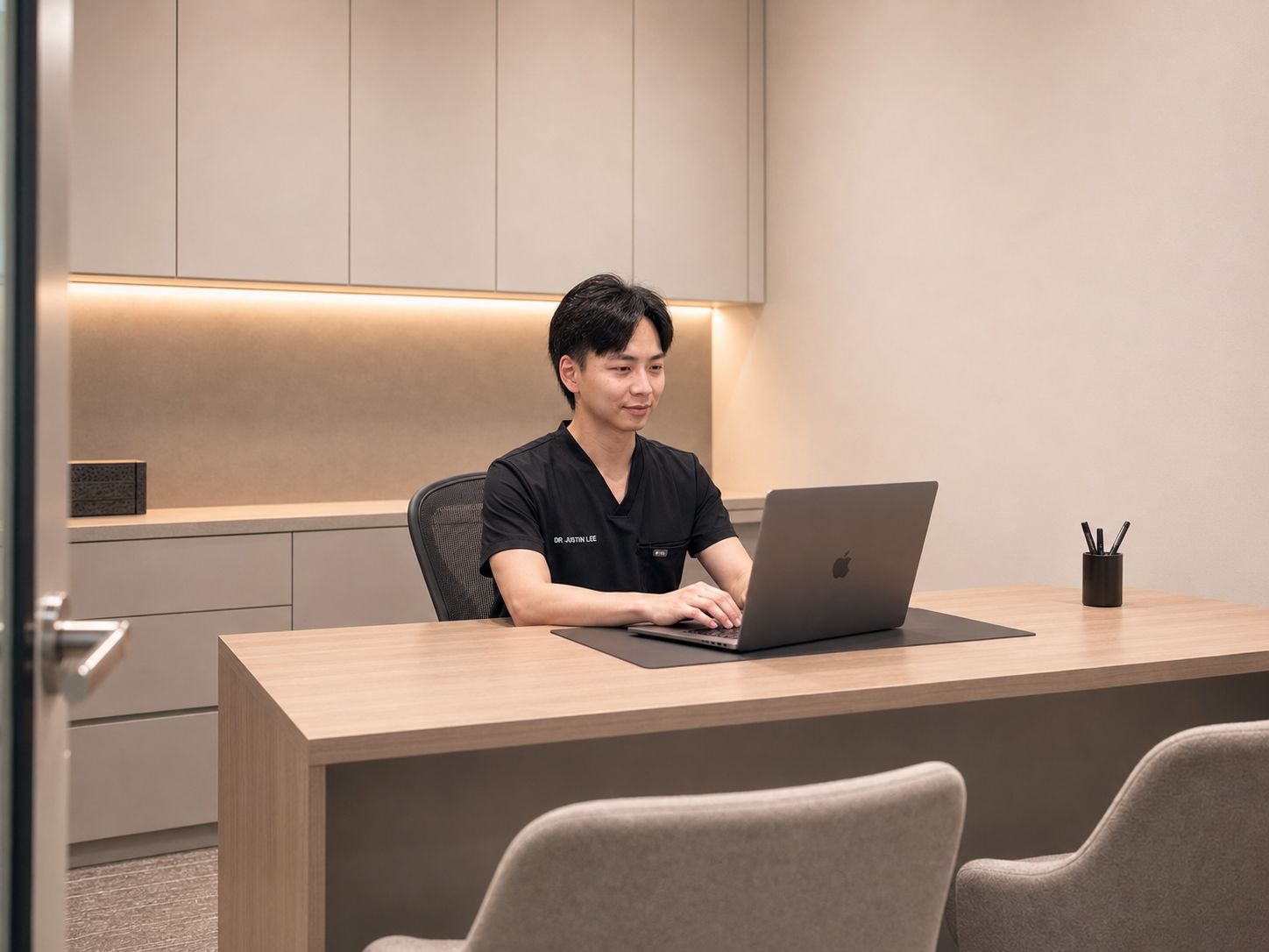 Dr Justin Lee reviewing notes at the Pacific Smiles Dental Belconnen clinic